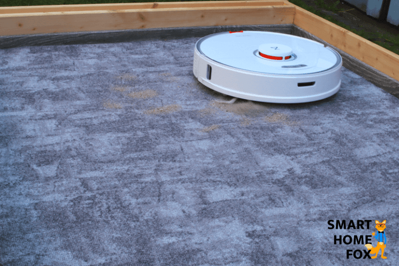 Roborock S7 beim Sand-Saugtest auf einem niedrigen Teppich